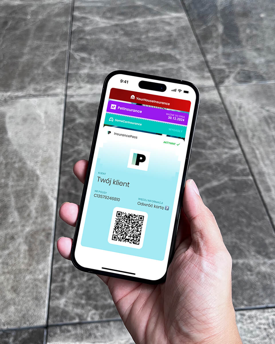 A hand holding an iPhone with iPhone Wallet cards visible