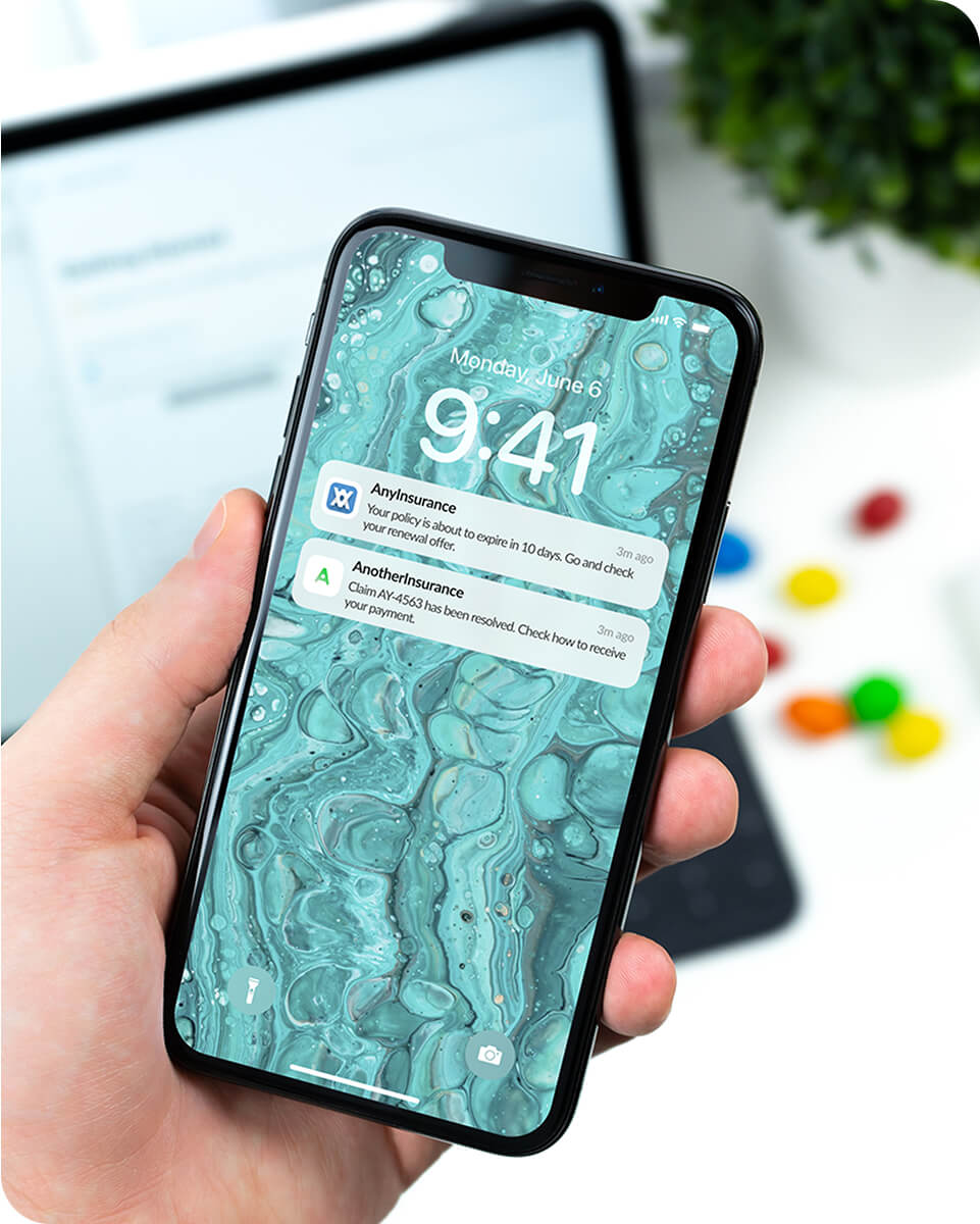A hand holding an iPhone with reminders on screen